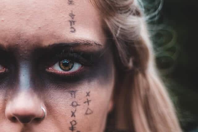 Man sowing the evil eye meaning. Black paint on his face.