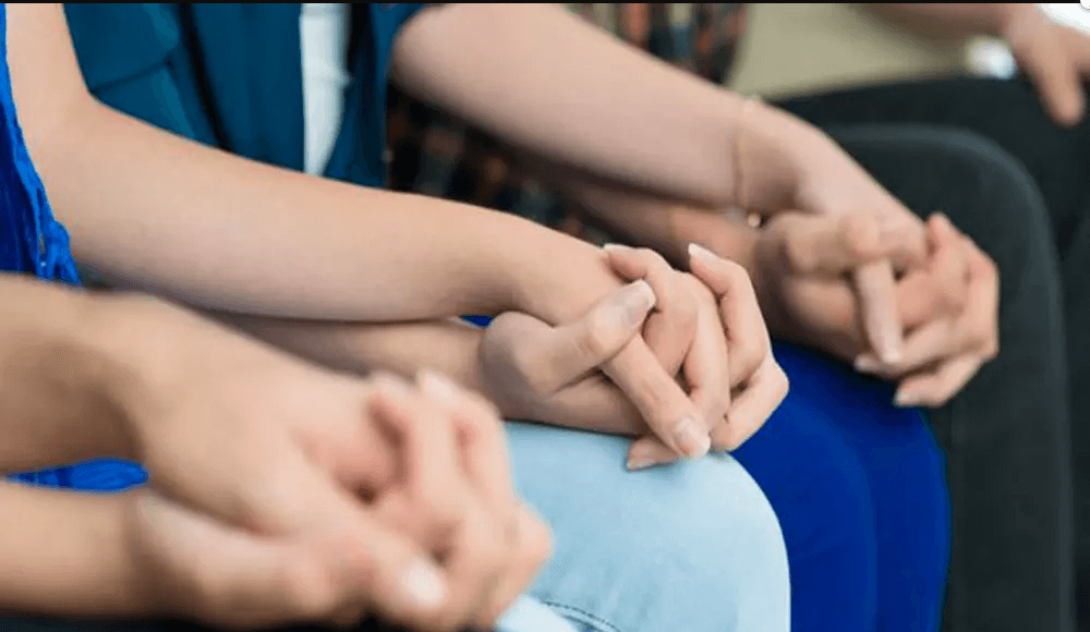 Family black magic, 3 people sitting holding hands.