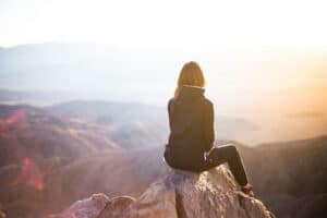 Spiritual health, Woman sitting on a mountain.