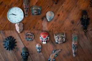 Signs of demonic possession, masks from differnt demons and a clock on a table.