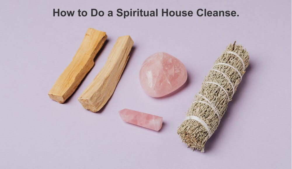 Spiritual house cleanse, wood, crystals and sage on a light purple surface.