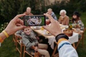 How to break a curse, family sitting at table together taking a picture with a mobile phone.