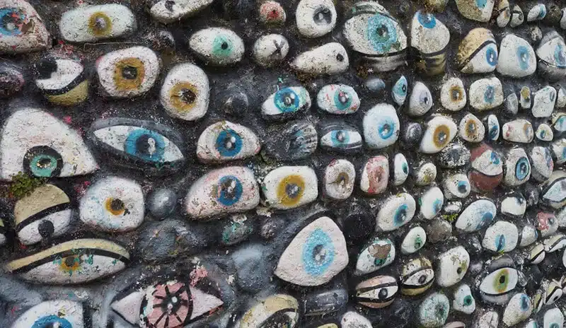 How to prevent nazar, rock wall with many different eyes painted on it.