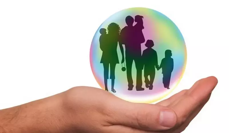 Magic protection, hand holding bubble with family in it.
