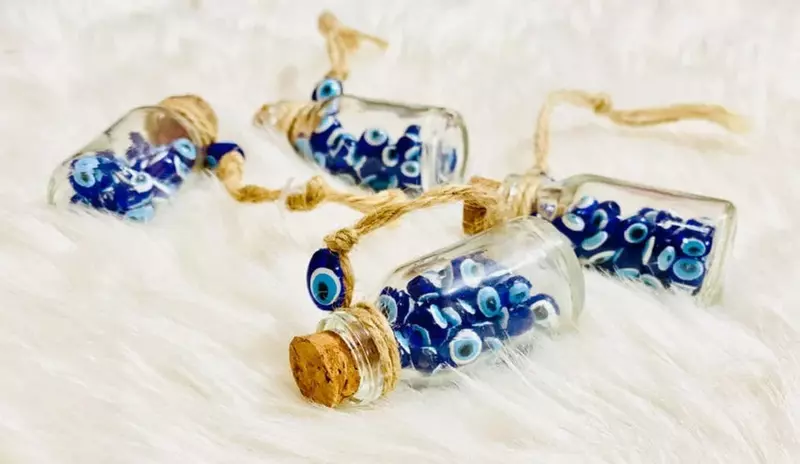 Protection from evil eye, small glass evil eye beads in four glass jars.