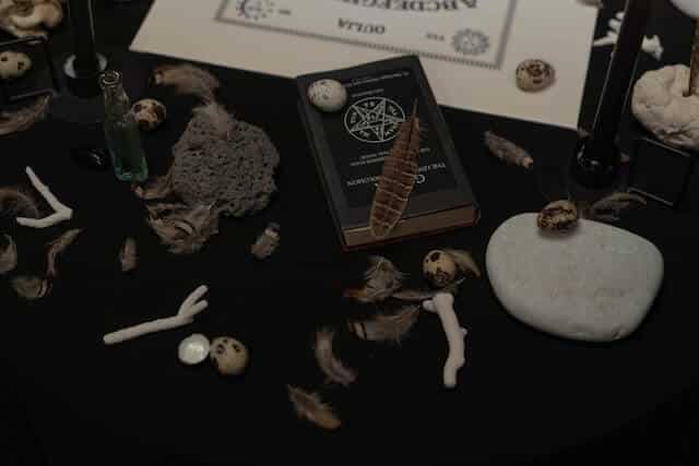 Black magic removal, bones and a witchcraft book on a table.