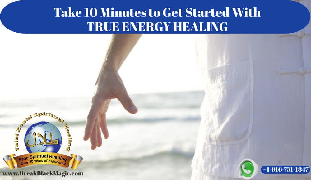 Energy healing, man wearing white with arm out in front of the ocean.