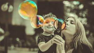 Family Curse Removal, mom and son blowing bubbles.