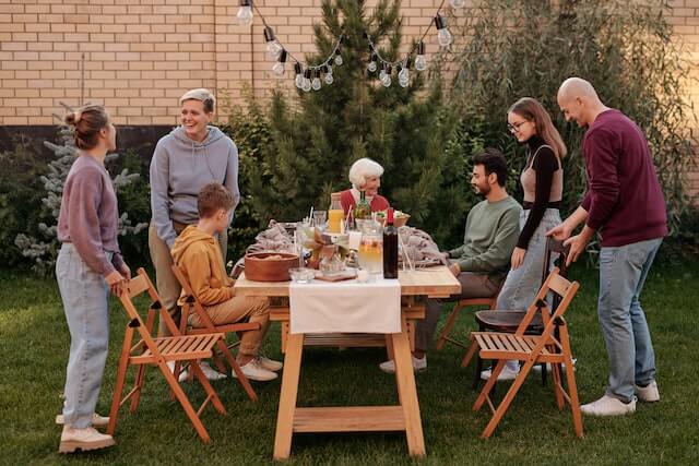 Family healing emotionally sitting around a dinner table4 outside.