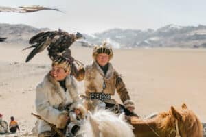 Boy on a horse with positive energy catching a hawk.