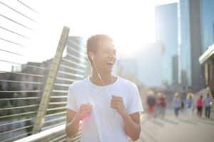 Man walking on a bridge with sun shine behind him with positive energy.