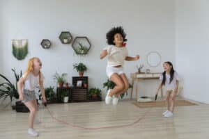 Multi culture girls with positive energy jumping with jump rope n a house.