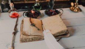 Remove black magic, book and a key and feather inside on a table.
