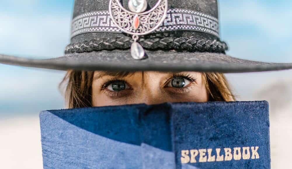 Signs of black magic. Woman holding spell book.