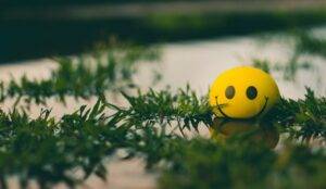 Happy face stress ball floating on water with positive energy.